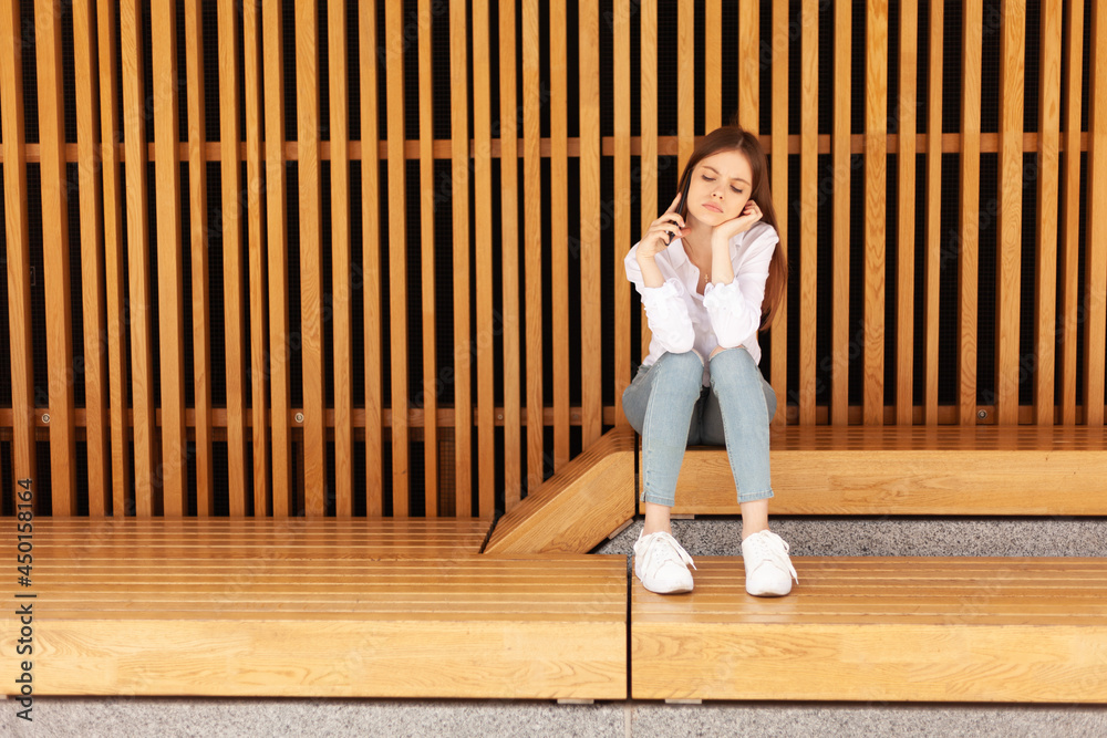 Upset young woman talking on a smartphone. Phone fraud. Poor customer service. Upset young woman talking on a smartphone. Phone fraud. Poor customer service.