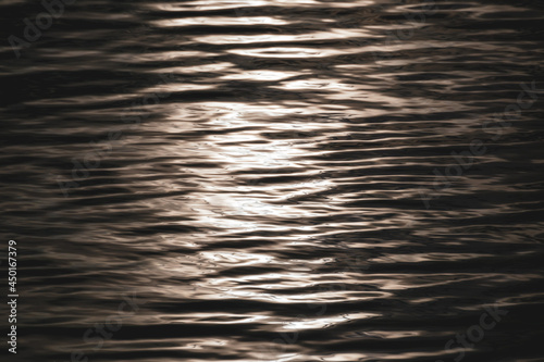 Shining water with reflections. Metallic ripple water surface pattern. Wave texture close-up