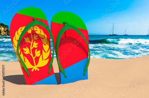 Flip flops with Eritrean flag on the beach. Eritrea resorts, vacation, tours, travel packages concept. 3D rendering