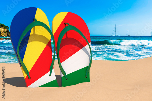 Flip flops with Seychelloise flag on the beach. Seychelles resorts, vacation, tours, travel packages concept. 3D rendering