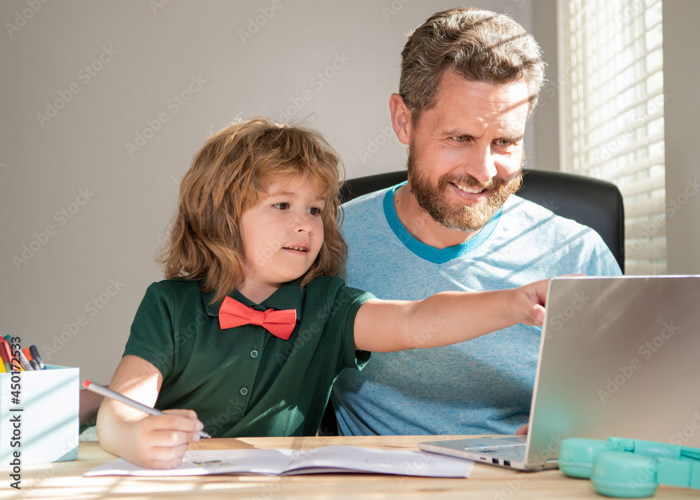 smiling father and son use communication technology at home. family blog. boy do homework smiling father and son use communication technology at home. family blog. boy do homework