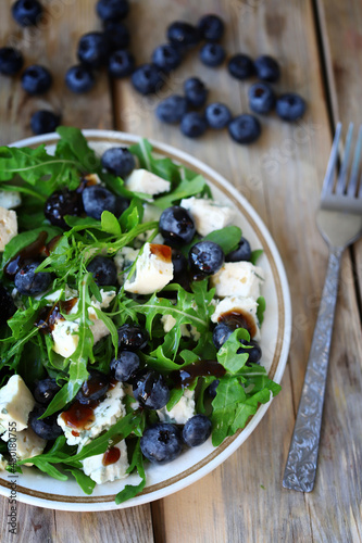 Healthy tasty salad with arugula, blue cheese and blueberries. Keto salad. Summer health food.