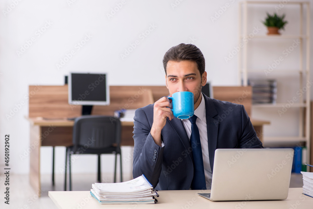 Young male employee drinking coffee during break Young male employee drinking coffee during break