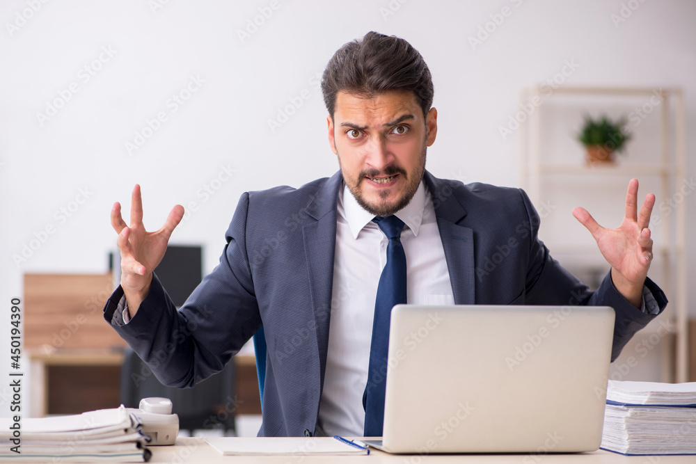 Young male employee sitting at workplace Young male employee sitting at workplace