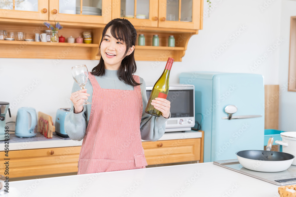 キッチンでお酒を飲む女性