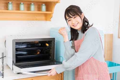 オーブンを使う女性