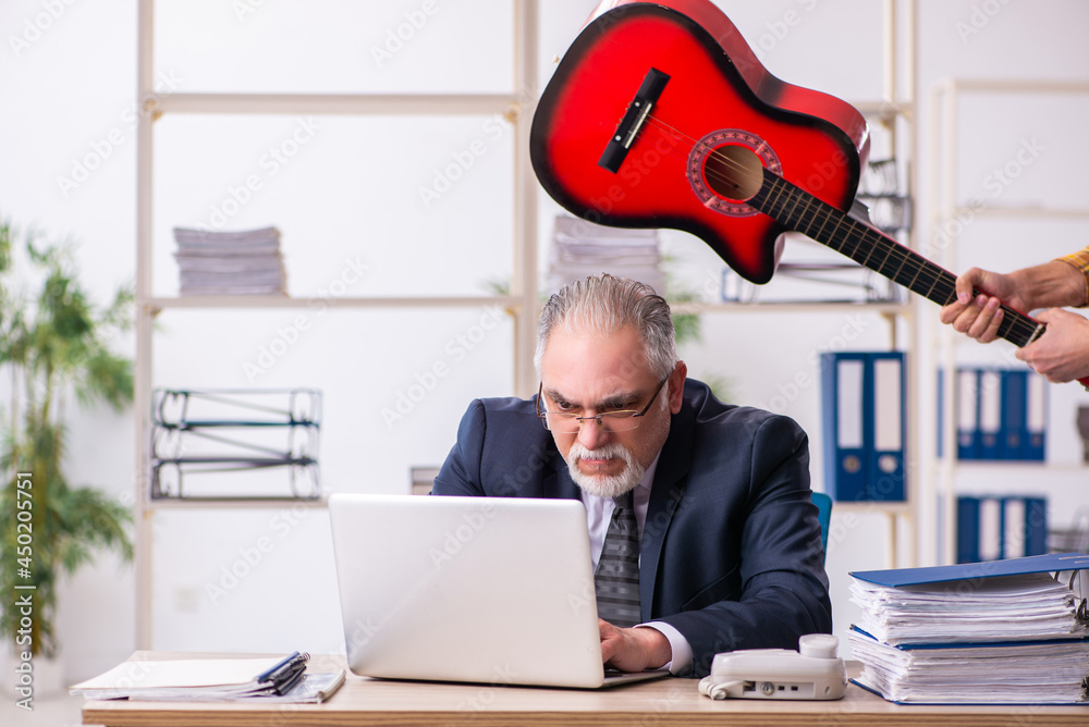 Old male employee unhappy with excessive work in the office Old male employee unhappy with excessive work in the office