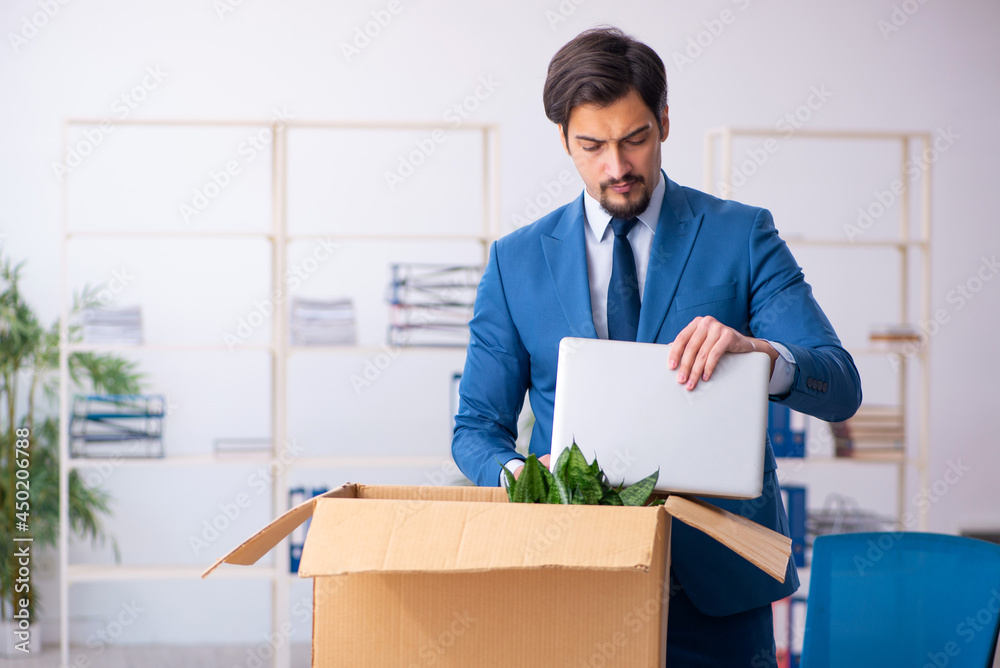 Young male employee in business relocation concept Young male employee in business relocation concept
