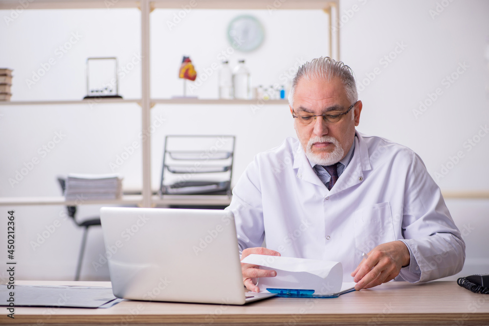 Old male doctor working in the clinic Old male doctor working in the clinic