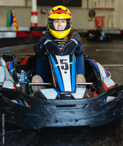 Positive female go-cart racer posing at cart circuit