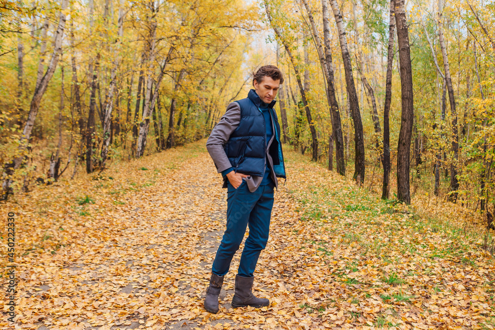 Tall handsome man walking in the autumn alley Tall handsome man walking in the autumn alley