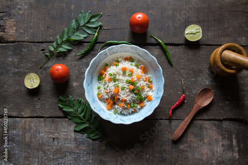 Vegetable pulao or flavoured basmati rice mix with vegetables served in a bowl. Top view.