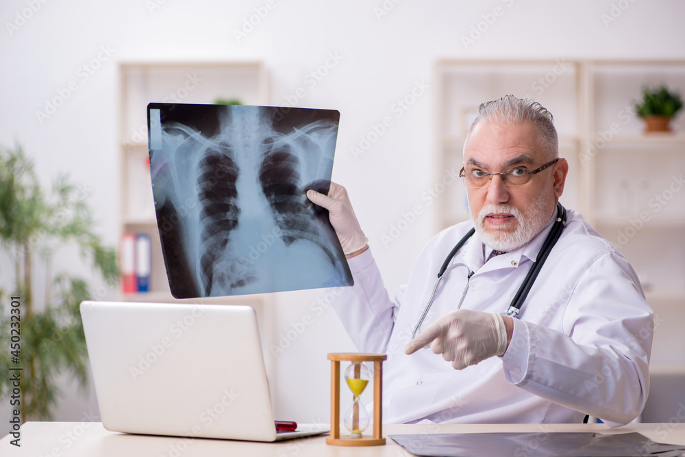 Old male doctor in time management concept Old male doctor in time management concept
