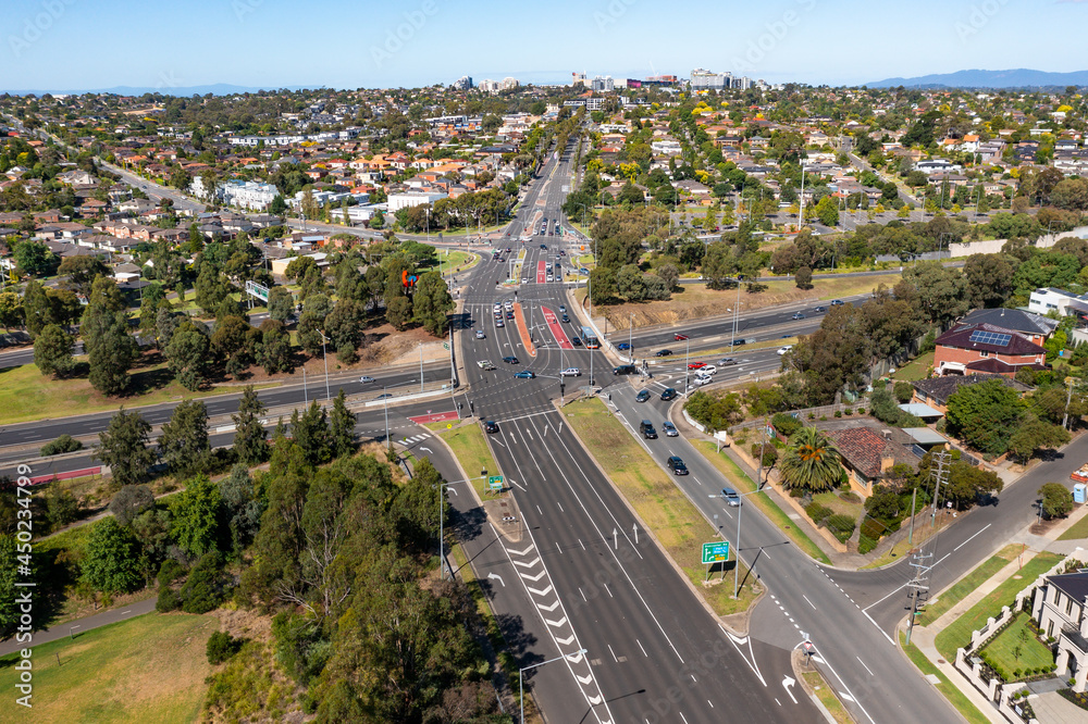 Horizontal aerial view of a freeway overpass with traffic, trees, and buildings on a sunny day Horizontal aerial view of a freeway overpass with traffic, trees, and buildings on a sunny day