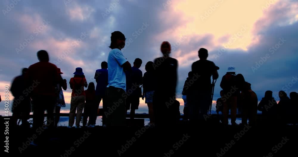 Silhouettes of tourist crowd waiting for the sunrise and doing activity, taking a photo, selfie with nature on the hill at viewpoint in time lapse shot. Silhouettes of tourist crowd waiting for the sunrise and doing activity, taking a photo, selfie with nature on the hill at viewpoint in time lapse shot.