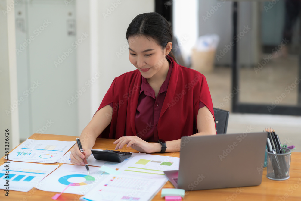 Businesswoman working with financial document and laptop computer in office. Businesswoman working with financial document and laptop computer in office.