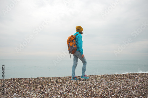 girl with a backpack on the seashore.
