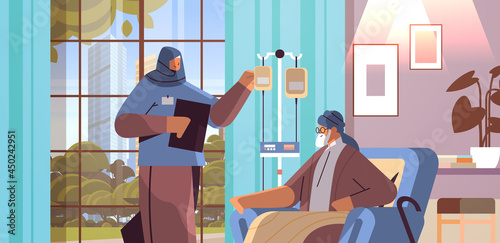 friendly arab nurse or volunteer checking dripper of elderly man patient home care services healthcare