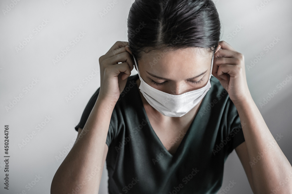 Asian woman medical staff putting face mask on her face against coronavirus. Coronavirus or Covid-19 quarantine. 