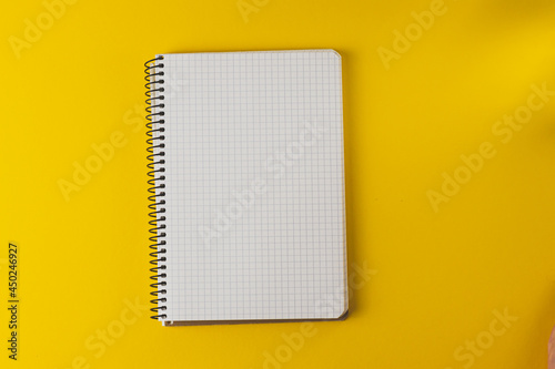 Open notebook in a cell on a yellow background. Copy space. Notepad isolated.mock up.