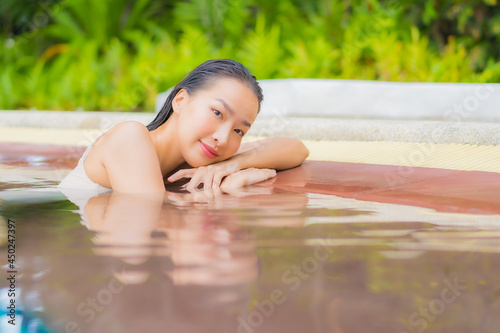 Portrait beautiful young asian woman relax around outdoor swimming pool