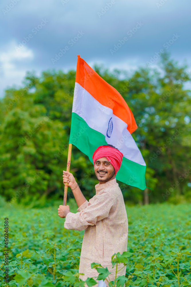 young indian farmer holding indian flag at agriculture field Stock