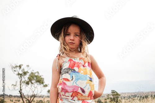 Young girl wearing grey bushman's hat in grassy fields photo