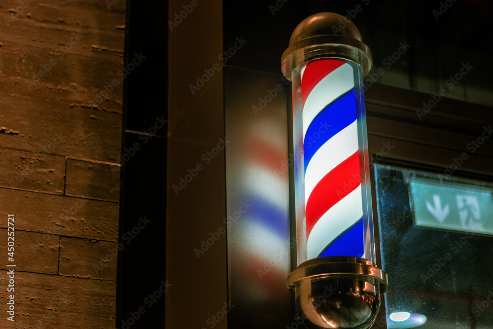 Barbershop pole sign attached to a wall of building