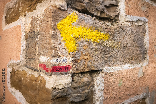 Yellow Arrow Pilgrimage Sign on House Corner Marking the Way of St James Pilgrim Trail Camino de Santiago photo