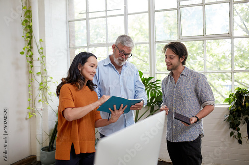 Three professional business people, sharing ideas in a studio office photo