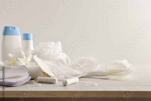 Menstrual hygiene products and toiletries on table white isolated background