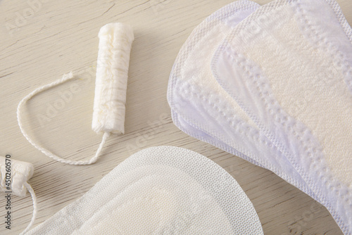 Background with female menstrual protectors on white wooden table closeup photo