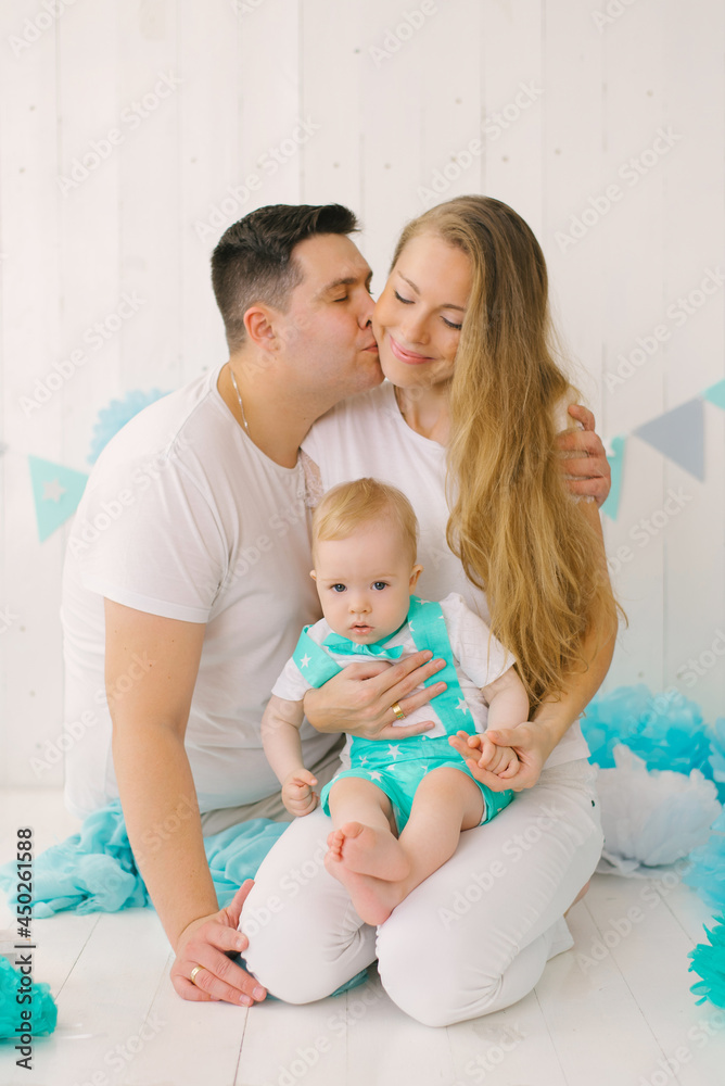 A beautiful young happy family with a one-year-old child, the Fa A beautiful young happy family with a one-year-old child, the Fa