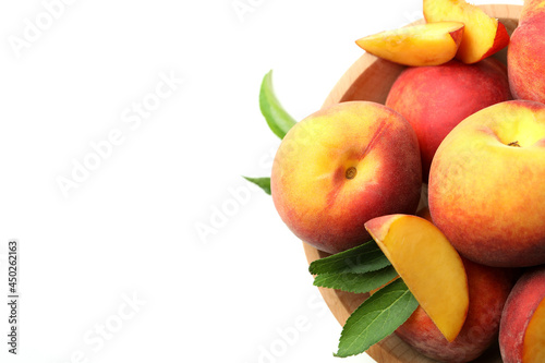 Wooden bowl with peach fruits on white background