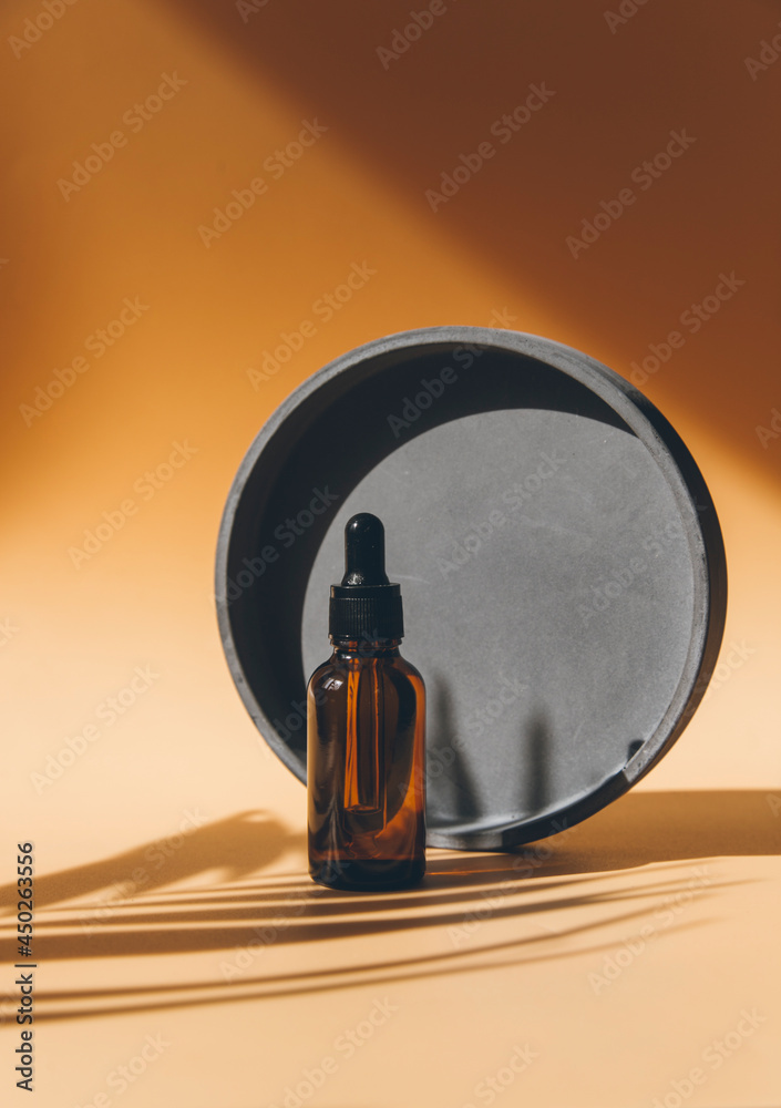 Dropper bottle on abstract background with round geometric shapes  for product presentation. Natural skin care beauty product concept.