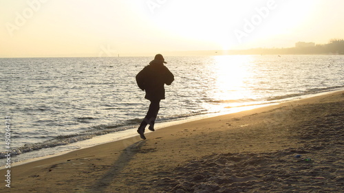 Człowiek biegnący po plaże zimą przy wschodzie słońca, Sopot, Polska 