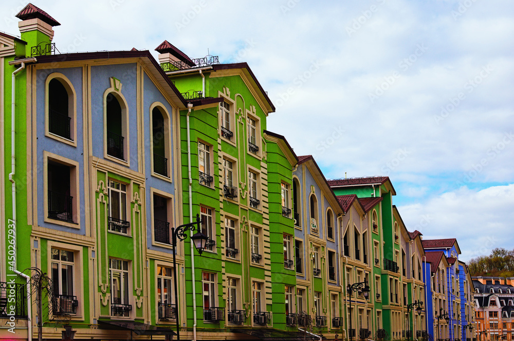 Naklejka premium Colorful buildings against blue sky. Modern neighborhood in the ancient part of Kyiv. Cozy street on Vozdvizhenka