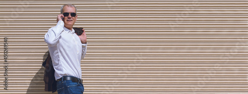 mature man using mobile phone on wall with copy space