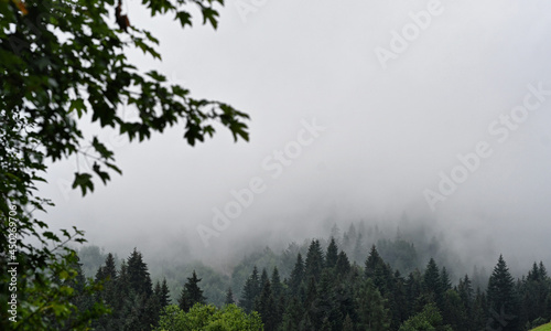 Clouds over the Ochotnica Gorna vilage hills during fogy day photo