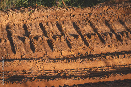 truck or heavy bulldoser or excavator caterpillar prints in sand in gravel quarry road.