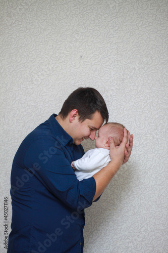 dad is a brunette with a little blond son. a newborn baby in dad's arms.