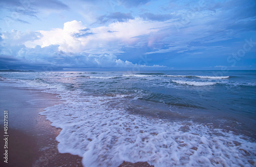 The nature of the waves spreads on the beach against the backdrop of the blue sky photo