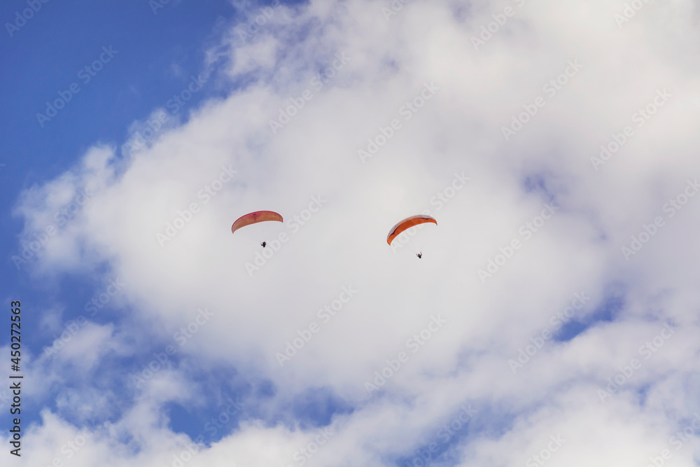 Paragliders Flying in the Blue Cloudy Sky Paragliders Flying in the Blue Cloudy Sky