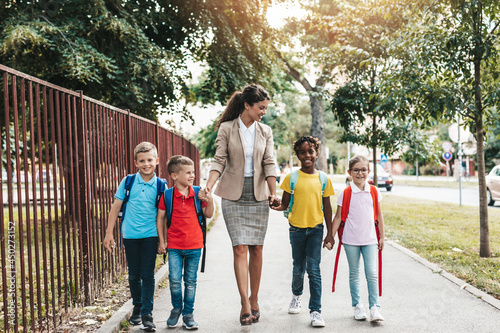 Mother taking her sons and their friends to school. photo