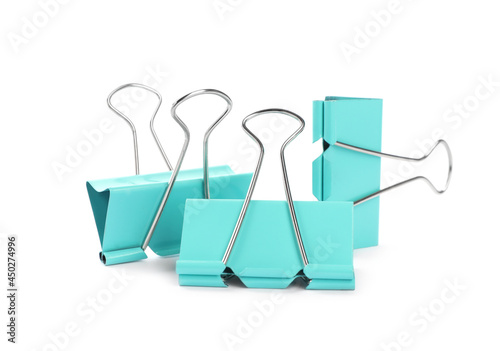 Turquoise binder clips on white background. Stationery