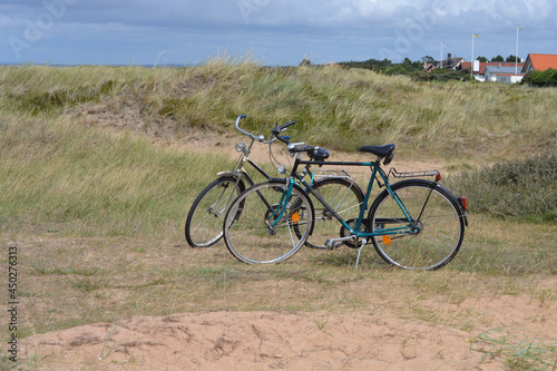 Deux vélos sur béquilles dans les dunes proches de la plage.