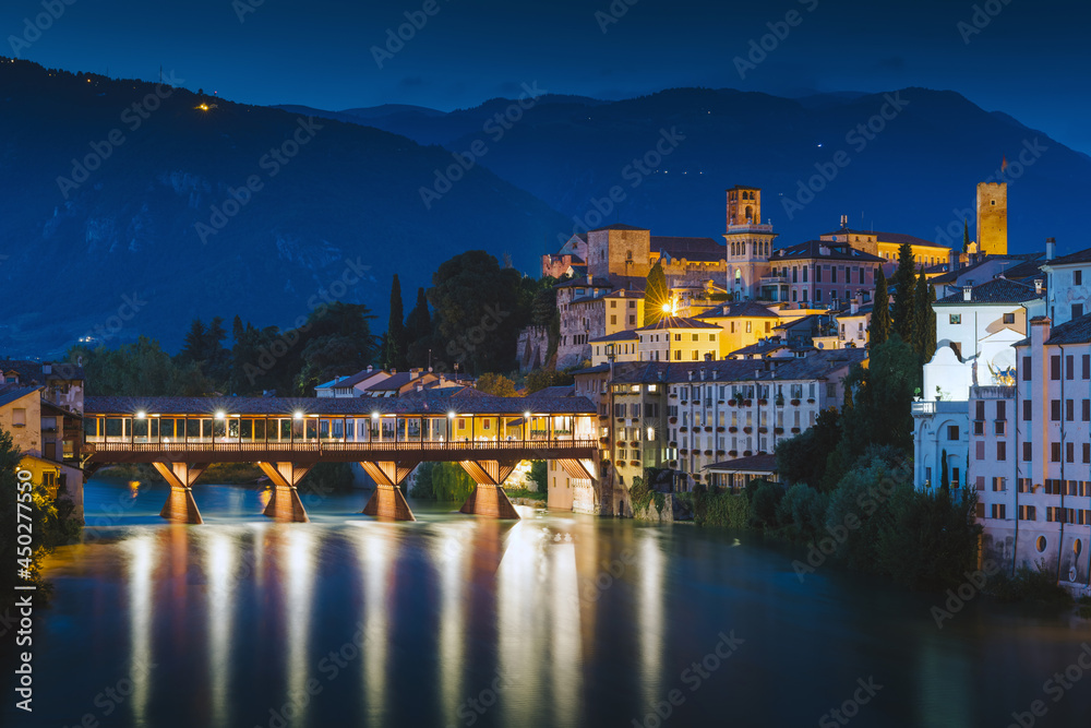 Bassano del Grappa, Italy. View of the Alpini bridge and the historic center from the Brenta river by night