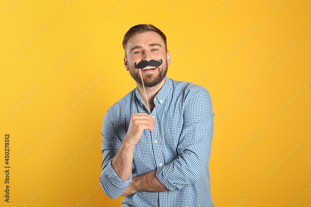 Funny man with fake mustache on yellow background Funny man with fake mustache on yellow background