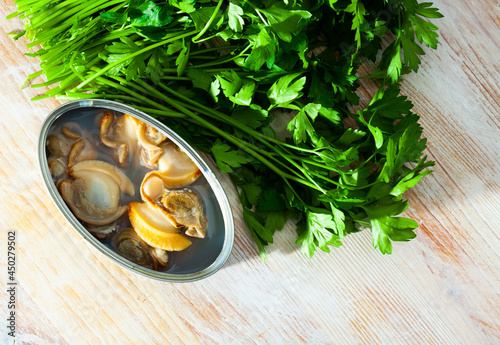 Canned mollusks in oil served on wooden table photo