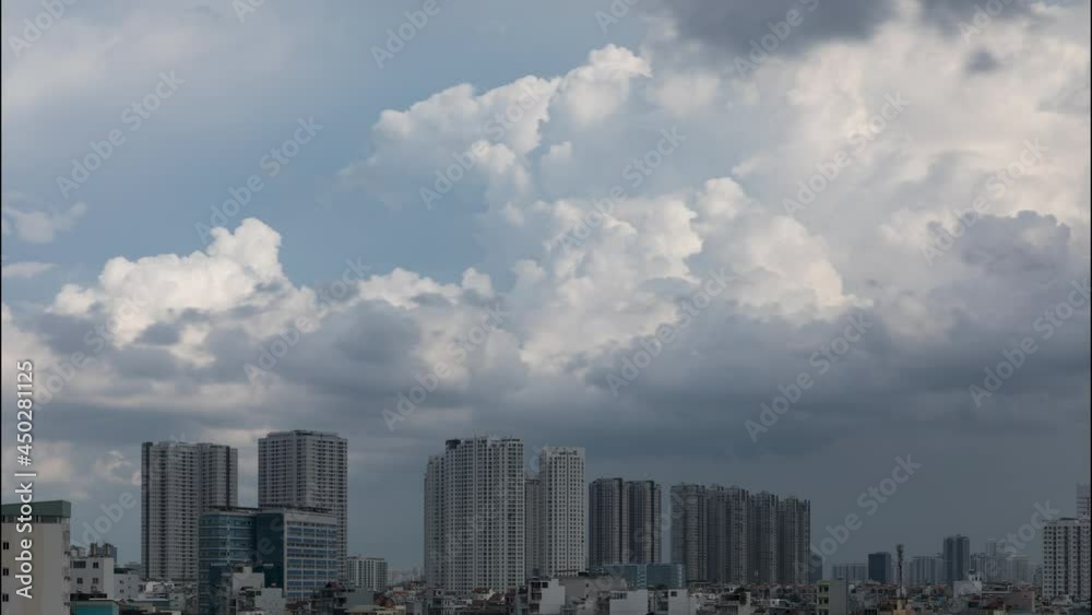 Time lapse of dramatic tropical clouds and sky during the day with large modern residential apartment blocks in Ho Chi Minh City Vietnam. Light changes creating shadows and highlights on the buildings Time lapse of dramatic tropical clouds and sky during the day with large modern residential apartment blocks in Ho Chi Minh City Vietnam. Light changes creating shadows and highlights on the buildings